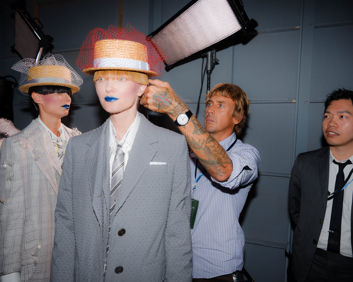James Pecis setting a hat and veil on a model backstage